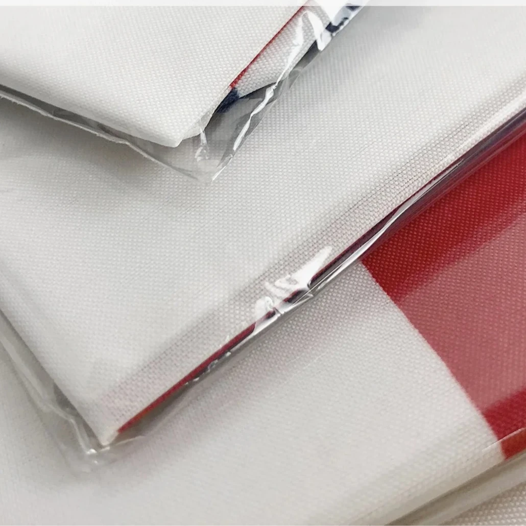 White fabric with red checkered pattern in clear packaging